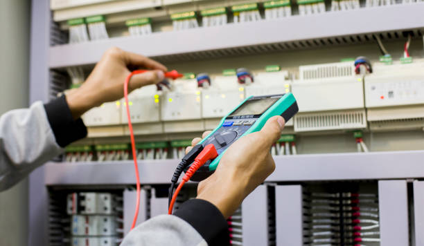 istock Electrician engineer work tester measuring voltage and current of power electric line in electical cabinet control. 1320301099
