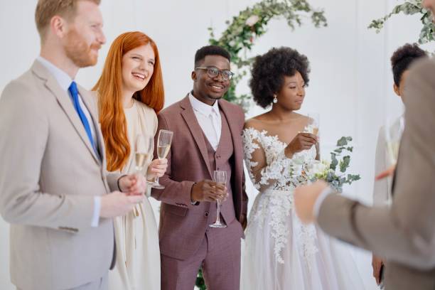 istock Newlyweds and wedding guests laughing and talking during party 1320301128