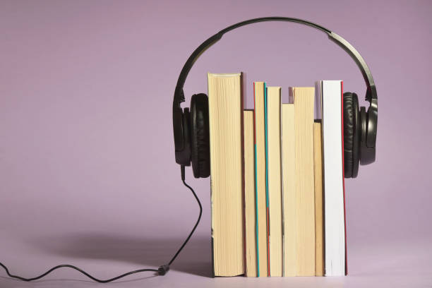 Audio books concept with books and headphones in studio stock photo