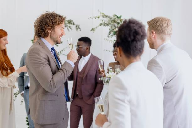 istock Newlyweds and wedding guests laughing and talking during party 1320302838