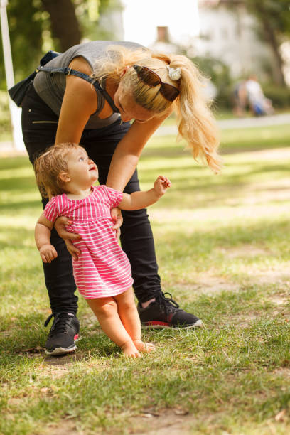 istock Cute baby girl experiencing grass barefoot while taking first steps 1320303636