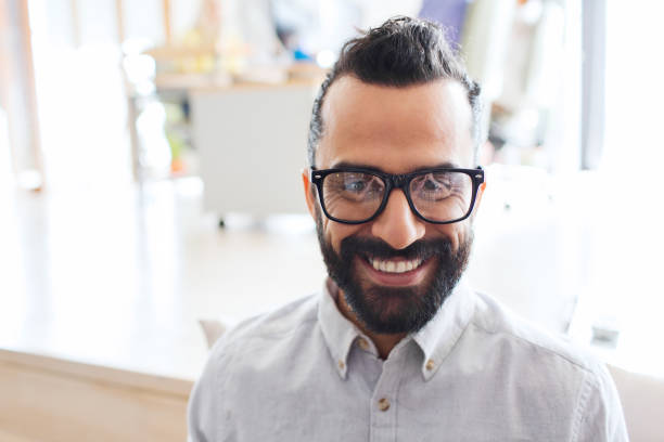 istock smiling man with eyeglasses and beard at office 1320303841