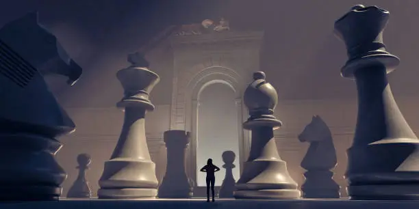 Photo of Small Female Figure Surrounded By Huge Chess Pieces Within An Ornate Old Building