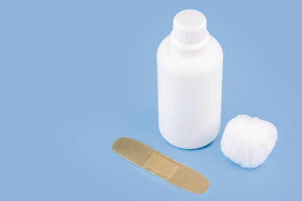 istock hydrogen perhydrogen peroxide, in white plastic packaging, with band aid and isolated blue background, antiseptic medicine 1320308469