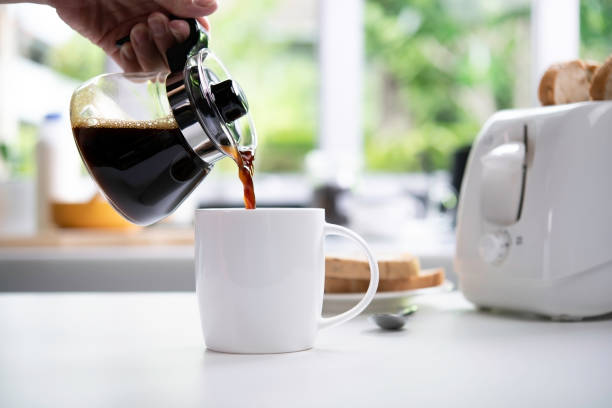 istock A hand pouring steaming coffee in to a cup on table in the kitchen 1320309129