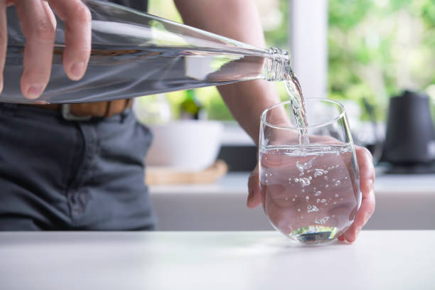 istock Pouring water into glass in the kitchen 1320309131