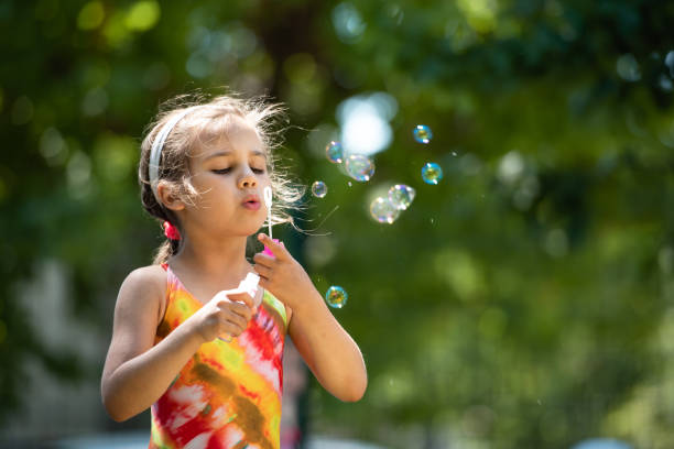 istock Child Blowing Bubbles In Summer Season 1320309306
