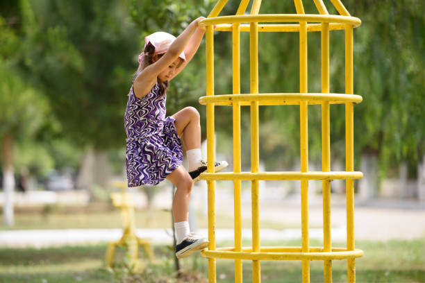 Child Girl Playing At Playground Outdoors In Summer