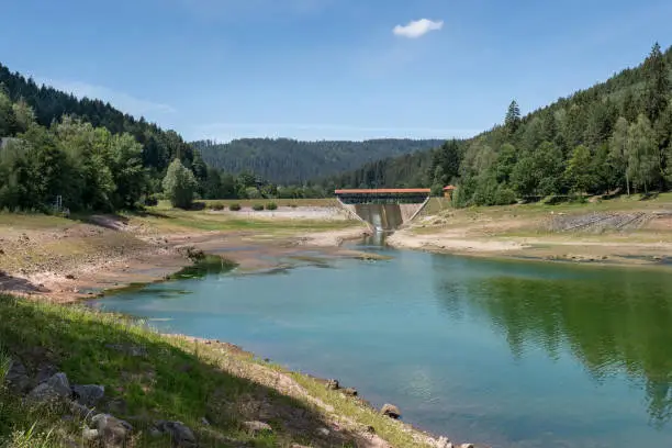 Dam Nagoldtalsperre, Black Forest, Germany, in summer at low water - lower lake with pedestrian bridge on the middle dike
