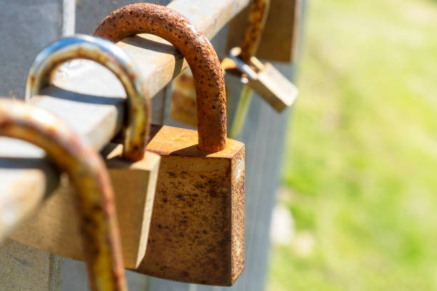 istock Old rusty iron closed padlocks on a metal fence 1320313033