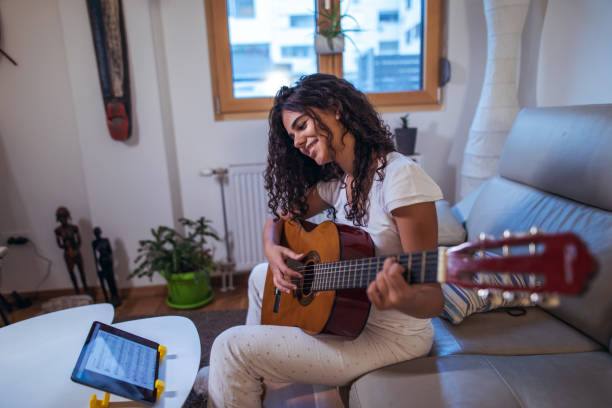 istock Girl learning guitar at home 1320313295