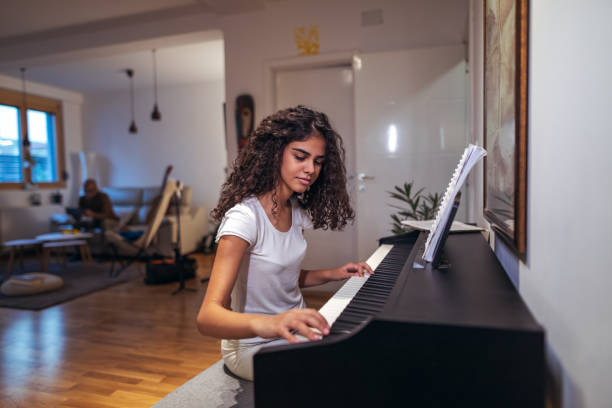 istock Girl playing piano at home 1320313310