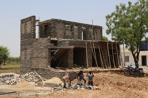 Beawar, Rajasthan, India, May 27, 2021: Labourers works at a construction site of a house on a hot summer day during ongoing COVID-19 lockdown in Beawar