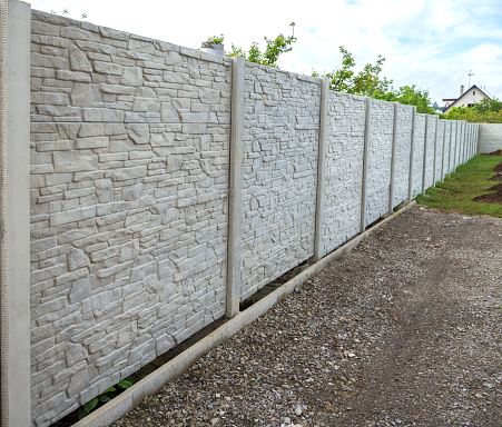 Concrete decorative fence from panels. Building site for house
