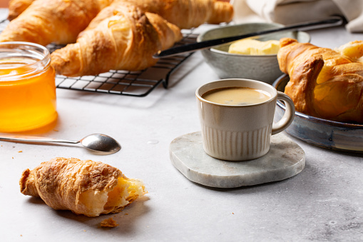 Coffee and croissants with honey and butter. Traditional continental breakfast.