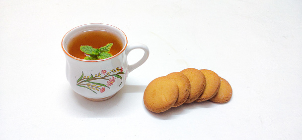 Closeup of Freshly Brewed coffee or Yea with Homebaked Wheat Biscuits or Cookies in a isolated White background with copy space for inscription. Food. Evening snack. Teatime.