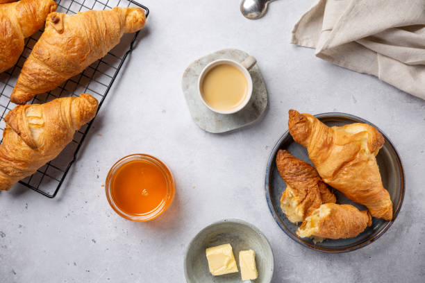 kaffee und croissants mit honig und butter. traditionelles kontinentales frühstück. essen hintergrund, top-ansicht. - butter bread breakfast table stock-fotos und bilder