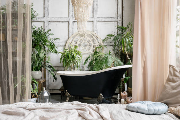 istock Freestanding bathtub surrounded by lush green plants 1320320339