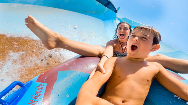 istock Mother and son speeding down fast on a water slide. 1320321269