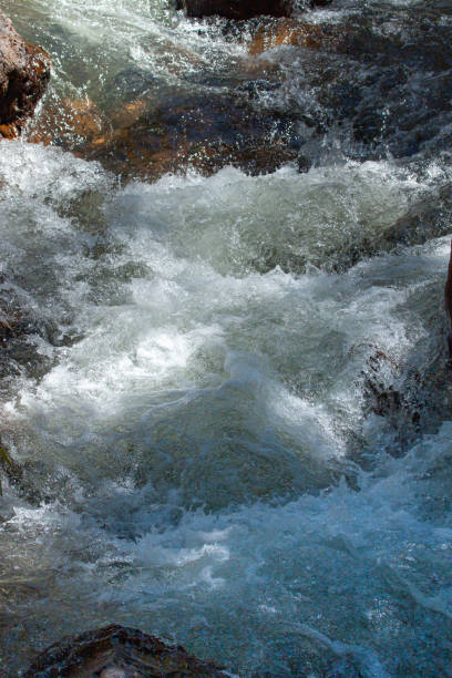 Photo of Clean and fresh mountain river flowing between the rocks. Front shot in fast flow.