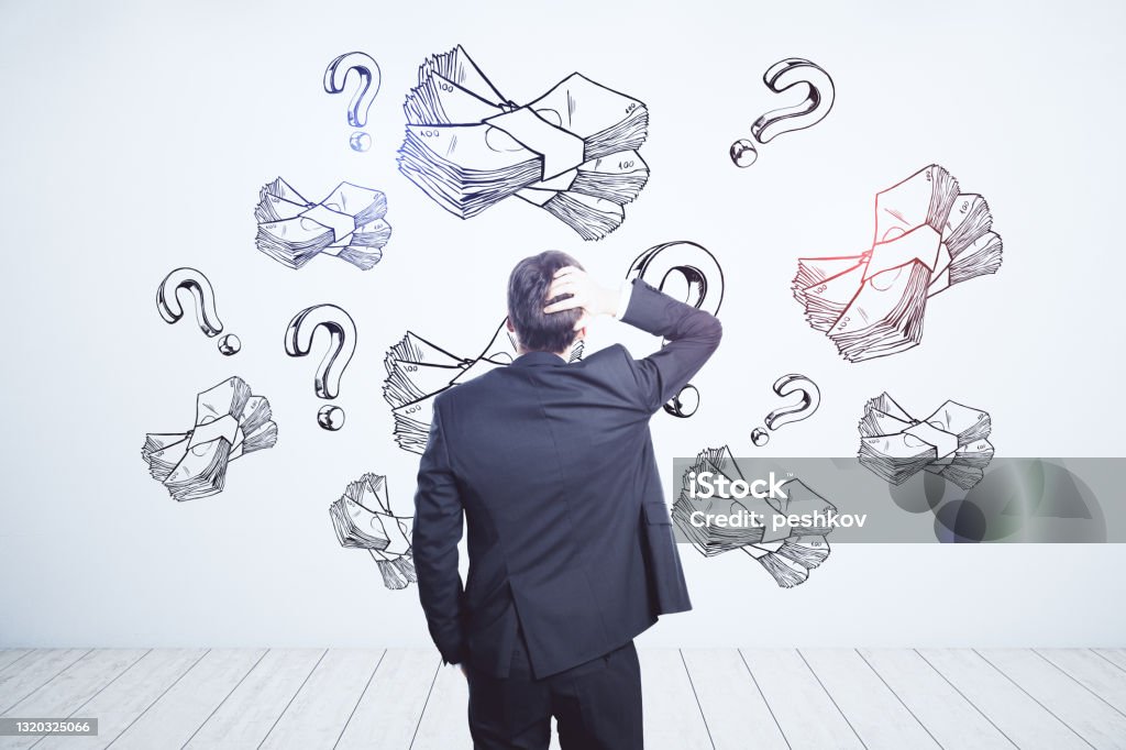 Earning money and business idea concept with pensive businessman looking at white wall with handwritten sketch of money packs and question marks. Earning money and business idea concept with pensive businessman looking at white wall with handwritten sketch of money packs and question marks Question Mark Stock Photo