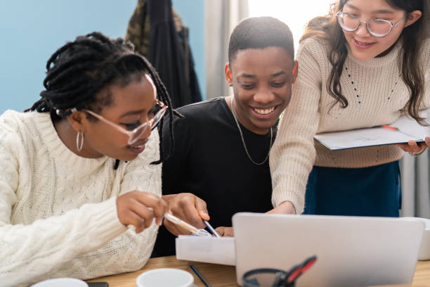 istock Three people of different nationalities responsible for a new company project work together, discuss marketing strategy, draw up a schedule of tasks, point out the most important sub-items 1320325450
