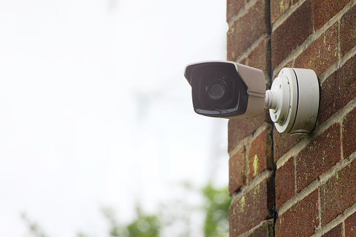 A security camera mounted to a brick wall