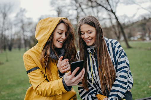 Friends using mobile in the park