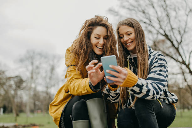istock Two friends sit on park bench 1320329628