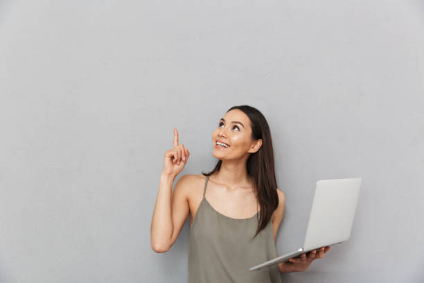 istock Portrait of a smiling asian woman using laptop computer 1320332117