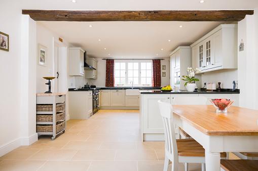 Open plan farmhouse kitchen dining room, with modern painted wood modular kitchen units, UK interior design