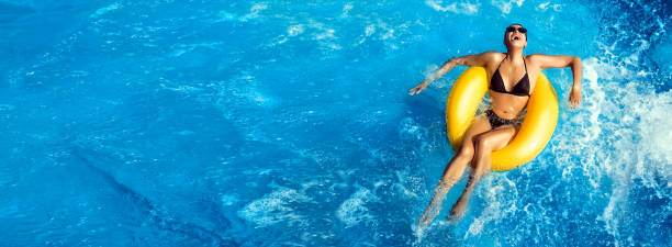 sommerurlaub. lachende junge frau genießt einen aquapark. spaß im pool - swimwear women swimming pool people stock-fotos und bilder