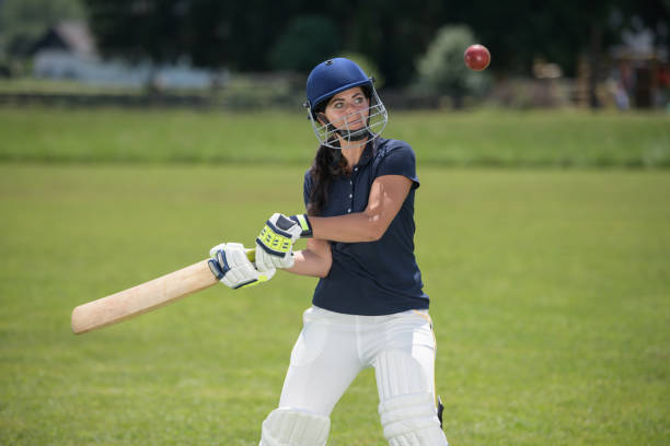 weibliche cricketspielerin schlägt den ball mit ihrem schläger - batting gloves stock-fotos und bilder