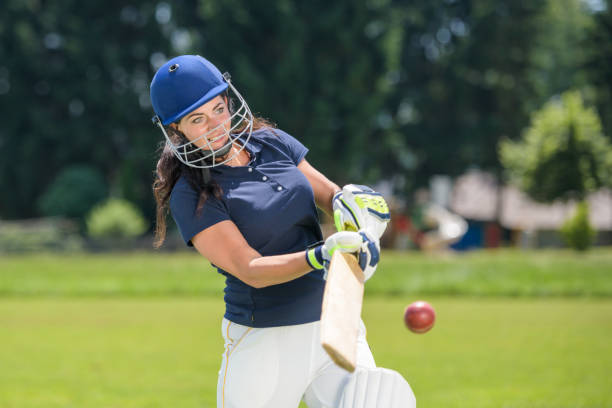 weibliche cricketspielerin schlägt den ball mit ihrem schläger - batting gloves stock-fotos und bilder