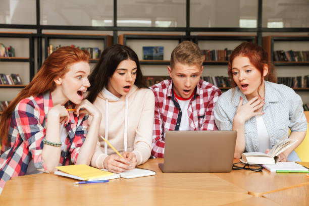 istock Group of excited teenagers doing homework 1320341266