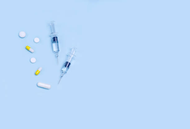 istock syringes with medication, capsules, vitamins and tablets on a blue background. concept comprehensive treatment and support of the body during the epidemic 1320341345