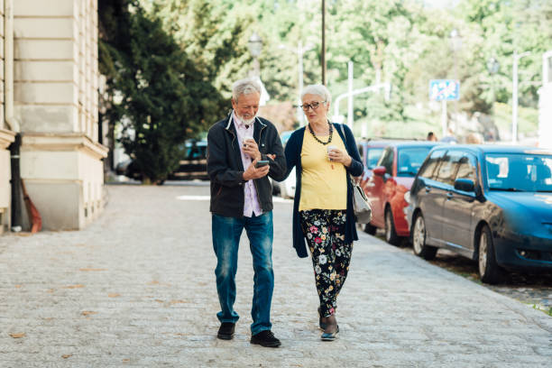 istock Happy senior couple walking and using smartphone 1320342025