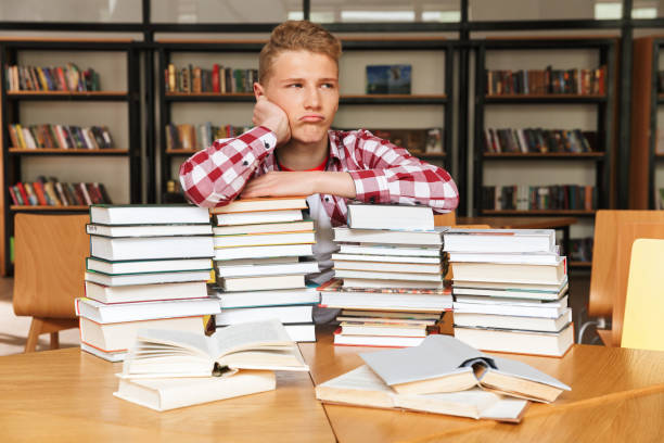 istock Bored teenage boy sitting at the library 1320342727