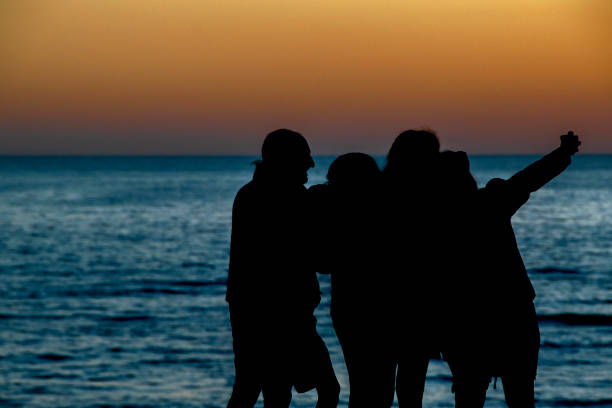 istock People at Beach Sunset Silhouette Scene 1320342943