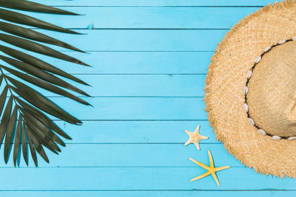 istock Palm leaf, straw hat and starfish on a blue wooden background, top view 1320345600