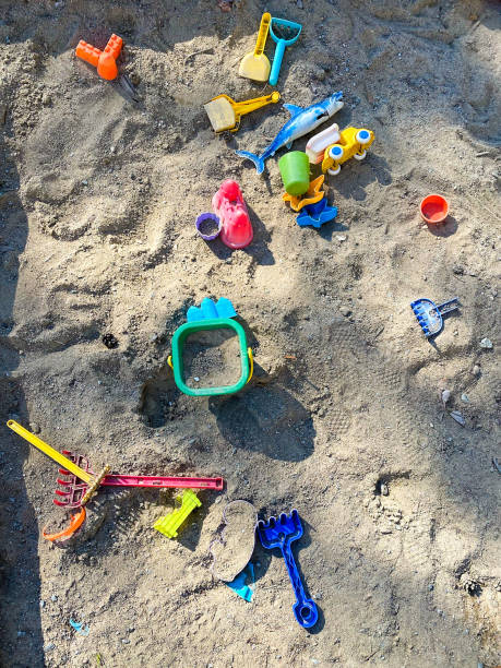 Colourful toys in a sandbox in sunlight.