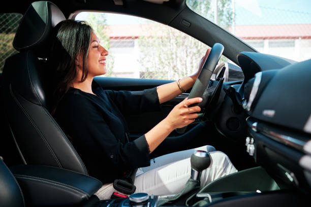 istock young latin woman driving luxury car 1320352059