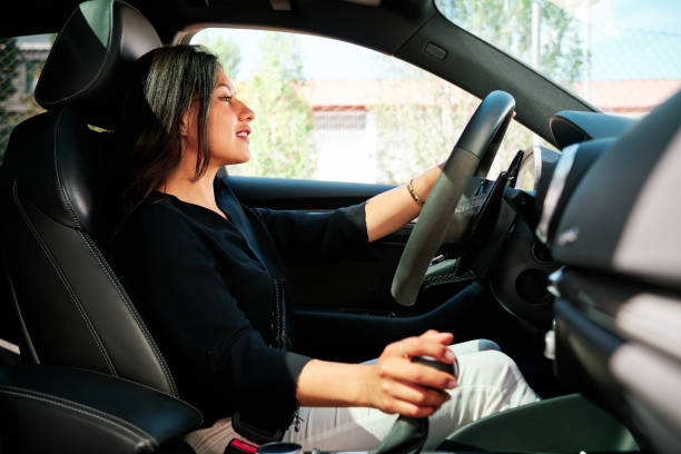 istock young latin woman driving luxury car 1320352063