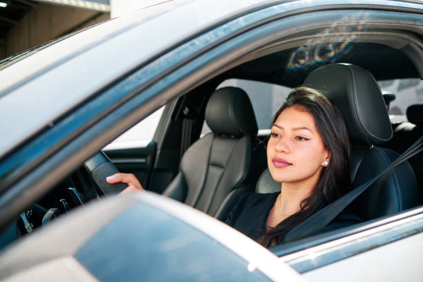 istock young latin woman driving luxury car 1320352087