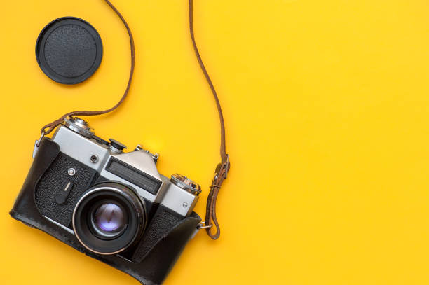 istock Retro film camera on yellow background 1320354917