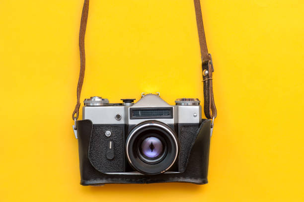 istock Retro film camera on yellow background 1320354949