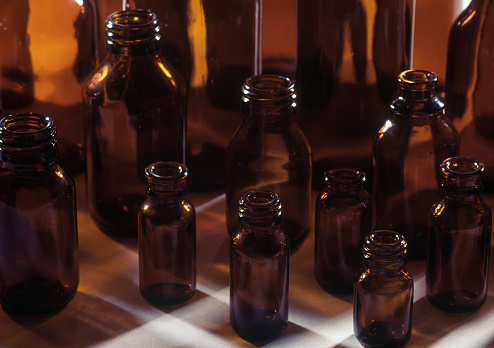 Amber empty medicine bottles of different sizes on white surface