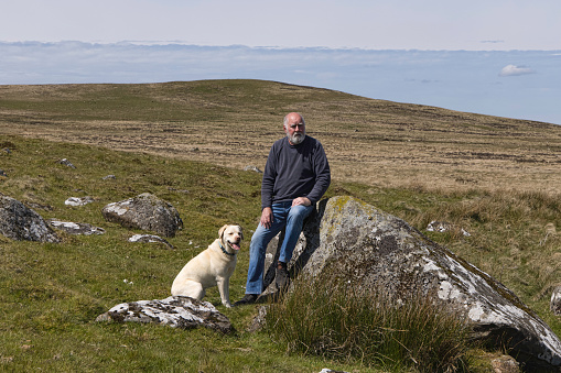 Senior man out walking with his dog in the Preseli Hills, Pembrokeshire.