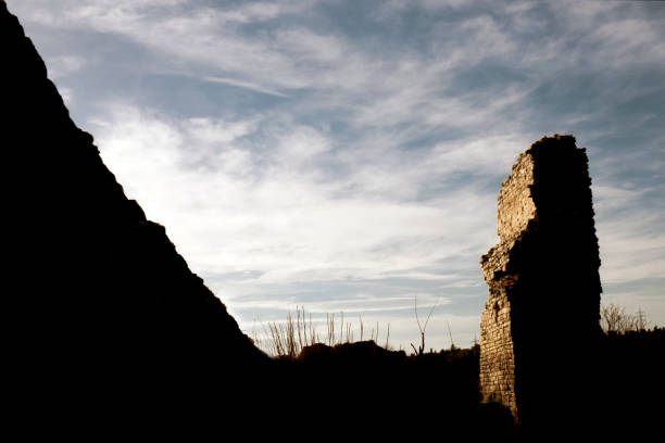 Part of historical Byzantine wall In Istanbul. Part of the wall was photographed in silhouette towards the cloudy sky.