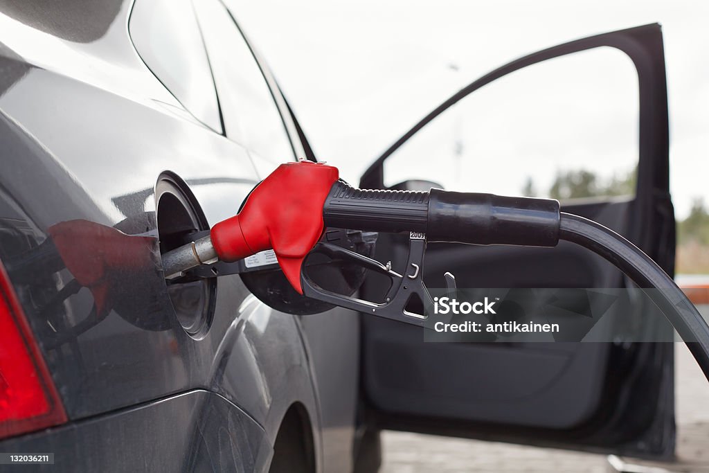 Refueling nozzle in the tank car at a gas station Refueling nozzle in the tank car at a fuel filling column. Summer day. Black car Automobile Industry Stock Photo
